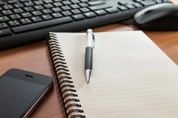 Pen op laptop met computertoetsenbord, muis en mobiele telefoon — Stockfoto