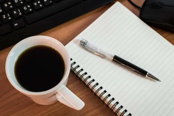 Ручка на ноутбуке с компьютерной клавиатурой, мышью и чашкой кофе — стоковое фото