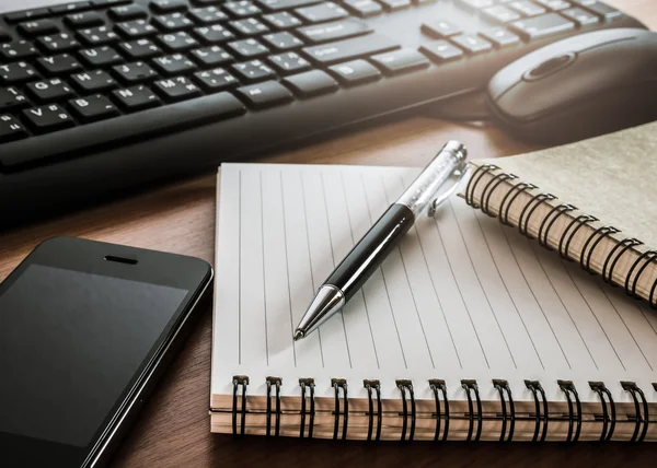 Pen op laptop met computertoetsenbord, muis en mobiele telefoon — Stockfoto