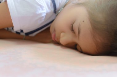 küçük kız yatakta uyuyor