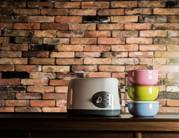 Colorful tiffin carrier and toaster on wooden cupboard — Stock Photo, Image