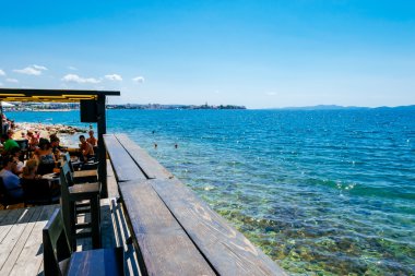 Zadar, Hırvatistan - 28 Temmuz 2015: Turist ve çeşitli Deniz kenarındaki barda oturan misafirler ve Zadar içinde güneşin tadını.