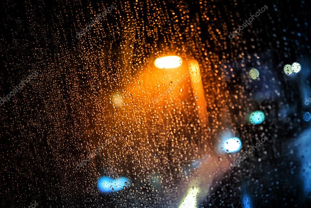 Rain drops on window with dark streets outside and street lights shining Stock Photo by ©marinv 67889751