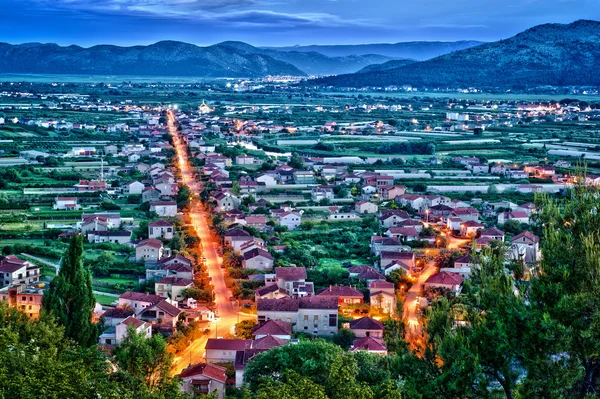 Flygfoto över en liten kroatiska stad i natt med starkt ljus — Stockfoto