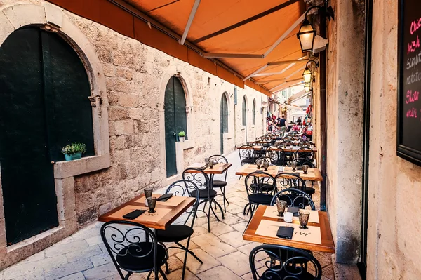 DUBROVNIK, CROAZIA - 10 APRILE: Terrazza ristorante nel centro storico di Dubrovnik, nelle stradine strette, sono pronti per i turisti provenienti da tutto il mondo il 10 aprile 2015 . — Foto Stock