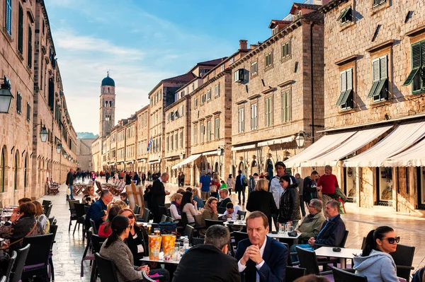 DUBROVNIK, CROAZIA - 10 APRILE: I turisti si godono le terrazze dei ristoranti nel centro storico di Dubrovnik sulla strada principale Stradun il 10 aprile 2015 . — Foto Stock