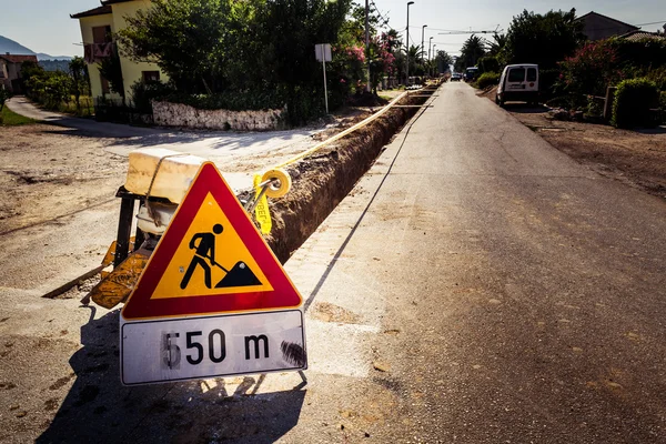 Straßenbauarbeiten. das Schild auf der Straße und ausgegrabene Straßen — Stockfoto