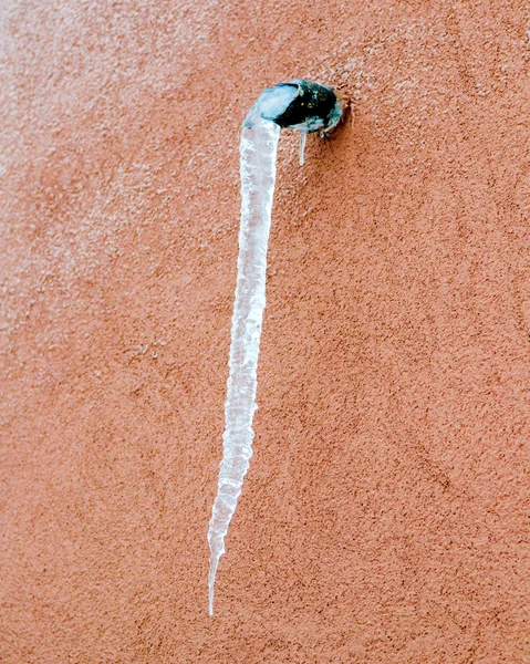 Long icicle hanging from the drain — Stock Photo, Image