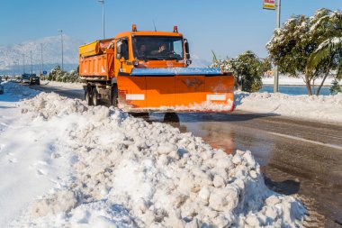 METKOVIC, CROATIA - FEBRUARY 5: Excavator cleans the streets of large amounts of snow in Metkovic, Croatia on February 5, 2012. clipart