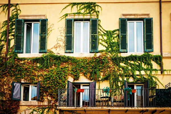 Balkon pełen kwiatów i zieleni zdobią domy i ulice w Rzym, Włochy — Zdjęcie stockowe