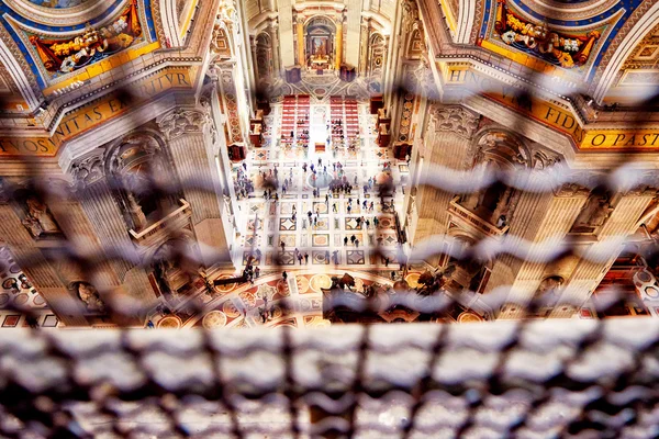 Los fieles y los turistas hacen un recorrido por el interior de la basílica de San Pedro en el Vaticano, Roma, Italia — Foto de Stock