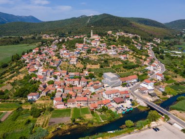 Hırvatistan 'ın Neretva Vadisi yakınlarındaki tarihi Vid köyü, Narona harabelerinin hava manzarası, tepe üzerindeki kilise ve yeşil kırsal manzara.