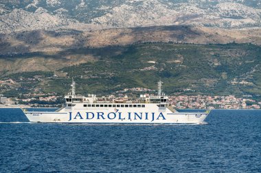 Split, Hırvatistan, 16 Temmuz 2019: Jadrolinija feribotu Marjan, arka planda Dalmaçya kıyı şeridi ve Mosor dağlarıyla Adriyatik Denizi 'ne yelken açıyor