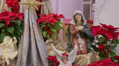 Bakire Meryem ile Katolik İsa 'nın doğumu sahnesi. Noel dini kırmızı çiçeklerle dolu bir hayat Dua ve inanç ayrıntıları