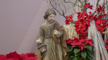 Aziz Joseph ile Katolik doğum sahnesi. Noel dini kırmızı çiçeklerle dolu bir hayat Dua ve inanç ayrıntıları