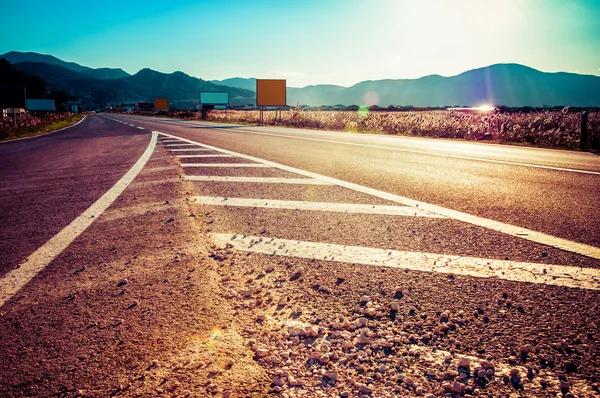 Asfalto strada lunga al tramonto — Foto Stock