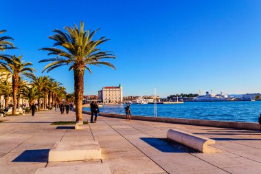 SPLIT, CROATIA - OCTOBER 1: Turists and residents walking along the sea side in historical part of Split, in Croatia on January 1, 2012.