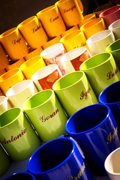 METKOVIC, CROATIA - JULY 20: Colorful coffee mugs with names  on sale at the fair in Metkovic, Croatia on July 20, 2011. — Stock Photo, Image