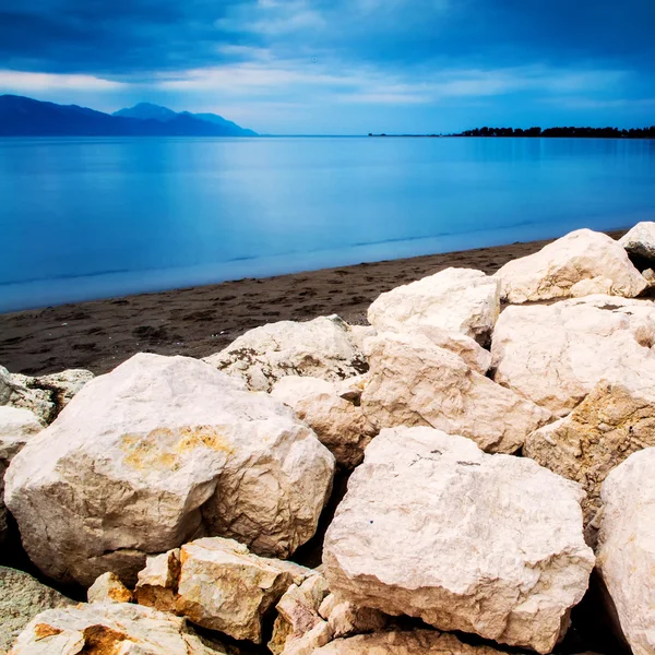 Cold and cloudy dany on the sand beach with rocks in front in so — Stock Photo, Image