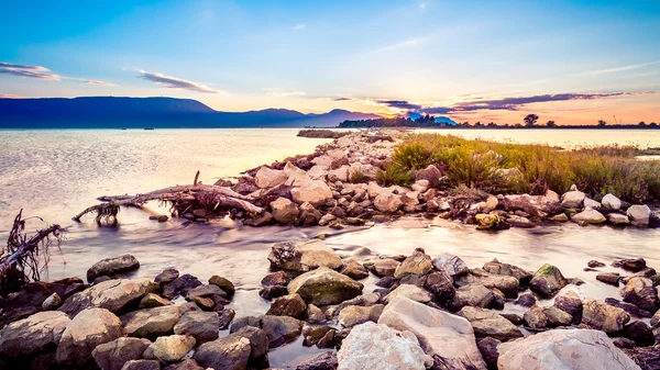 Beautiful summer sunset over the rocky shore by the sea. HDR ima — Stock Photo, Image