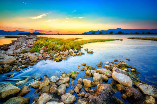 Beautiful summer sunset over the rocky shore by the sea. HDR ima — Stock Photo, Image