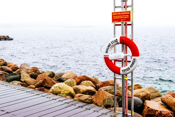 MALMO, SVEZIA - 31 DICEMBRE 2014: Bacini di legno e cintura di salvataggio in riva al mare nella giornata nuvolosa a Malmo, Svezia . — Foto Stock