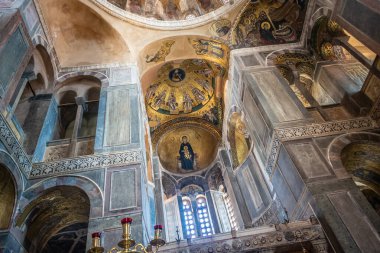 The golden murals with paintings of christ, mary and the apostles on the dome ceiling of Hosios Loukas monastery in Greece.