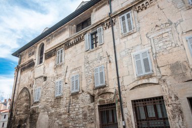 Hırvatistan 'ın Pula kentinde, üzerinde kemer ve dekoratif ayrıntılar bulunan eski, taş ev penceresi