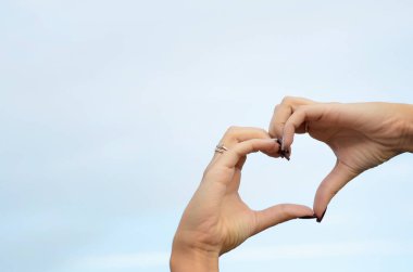 Eller gökyüzüne karşı bir kalp oluşturur.