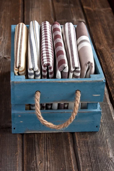 在乡村背景上的木盒子里的厨房毛巾 — 图库照片