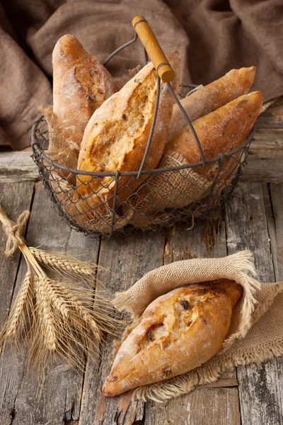 Pan con espiguillas de centeno en mesa de madera vieja — Foto de Stock