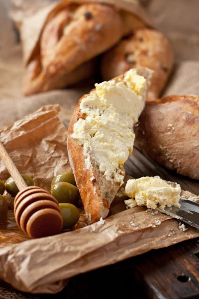 Pain frais avec crème au fromage sur le plateau en bois — Photo