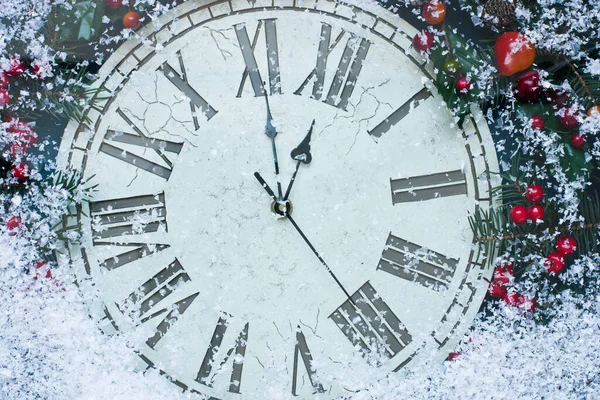 New Year's clock with decorations on snow. Celebration Concept for New Year Eve