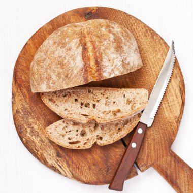 Hafif ahşap zemin üzerinde dilimlenmiş kepekli ekmeğin üst görüntüsü 