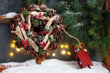 Noel çelengi ve köknar dallarıyla klasik ahşap pencere, seçici odaklı.