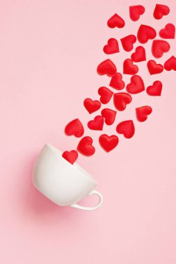 Beyaz kupa ve arka planda kırmızı kalpler, Sevgililer Günü konsepti