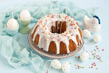 Ahşap masada seramik tavuklu ve dekoratif yumurtalı lezzetli paskalya pastası. Sığ alan derinliğine sahip seçici odak