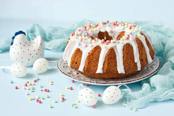 Lezzetli paskalya pastası, seramik tavuk ve ahşap masa üzerinde dekoratif yumurtalar.