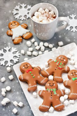 Bir fincan kremalı sıcak çikolata, eritilmiş marşmelov ve zencefilli kurabiyeler Noel tatili için.