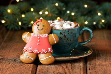 Sıcak çikolatalı seramik bardak, marşmelov ve ahşap arka planda zencefilli kurabiye Noel tatili için.