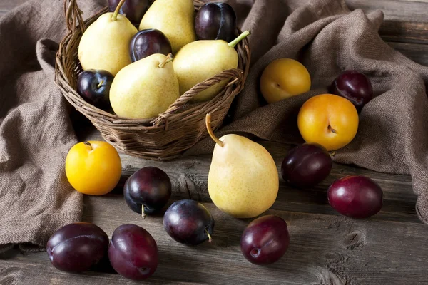 Ameixas e peras frescas na mesa velha — Fotografia de Stock