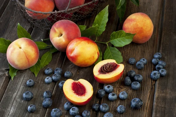 Kleurrijke zomer fruit - nectarines en perziken op houten tafel — Stockfoto