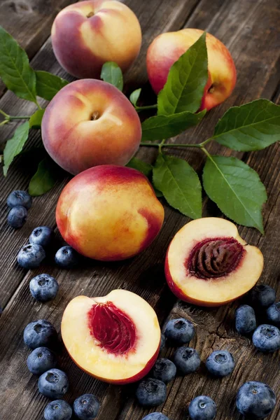 Colorful summer fruits - nectarines and peaches on wooden table — Stock Photo, Image