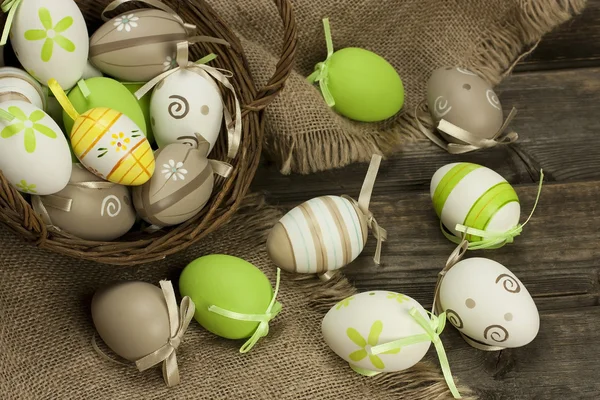 Different types of eggs in a basket on a wooden surface — Stock Photo, Image