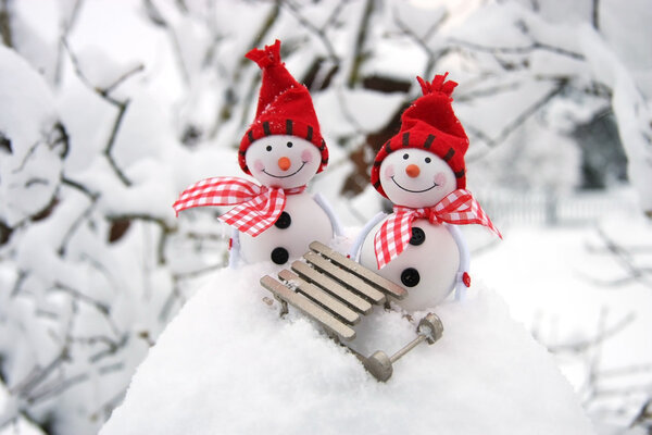 Two smiling snowmen friends in the snow