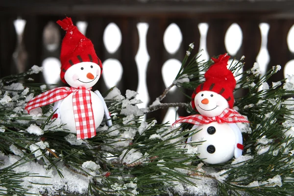Two smiling snowmen friends on fir-tree — Stock Photo, Image