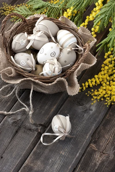 Hasır sepet içinde renkli Paskalya yumurtaları — Stok fotoğraf