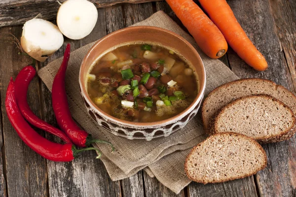 A healthy vegetarian bean soup in bowl on old wooden table — Stock Image A healthy vegetarian bean soup in bowl on old wooden table Royalty Free Stock Images