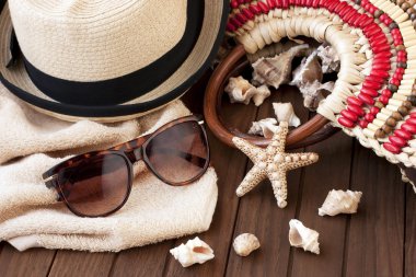 Havlu, güneş gözlüğü ve şapka ahşap arka plan üzerinde plaj çantası