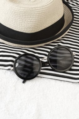 Hasır şapka, havlu ve güneş gözlüğü ile plaj öğeleri
